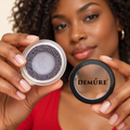 AI lifestyle image of a model holding Demure Castle Rock eyeshadow and its lid